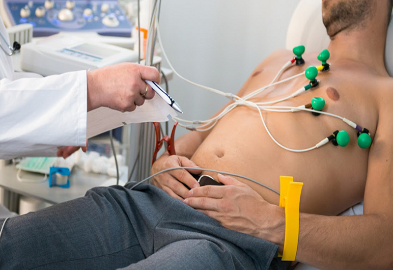 Một bác sĩ đang khám điện tâm đồ cho bệnh nhân để kiểm tra hoạt động điện của tim