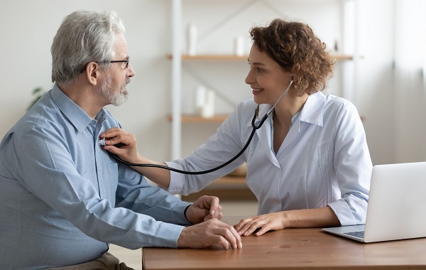 Bác sĩ tim mạch đang khám cho bệnh nhân đo huyết áp và nghe tim phổi